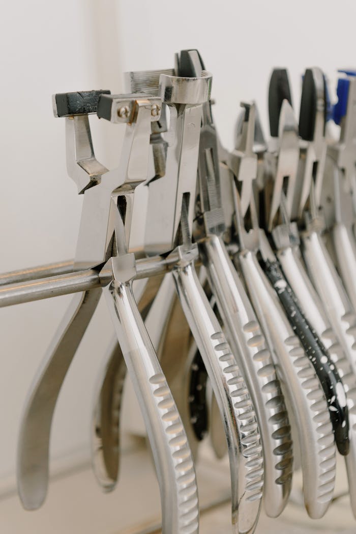 Assorted metal tools neatly hanging in a workshop setting for repair and maintenance.