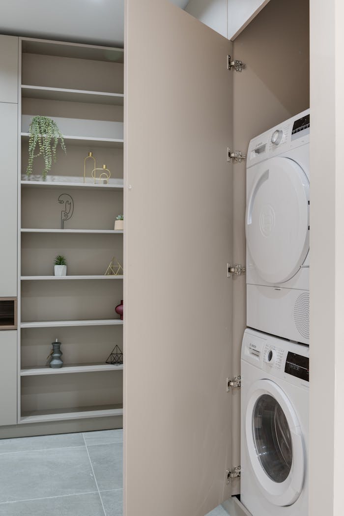 A stylish laundry area featuring stacked washer and dryer within a hidden cabinet.